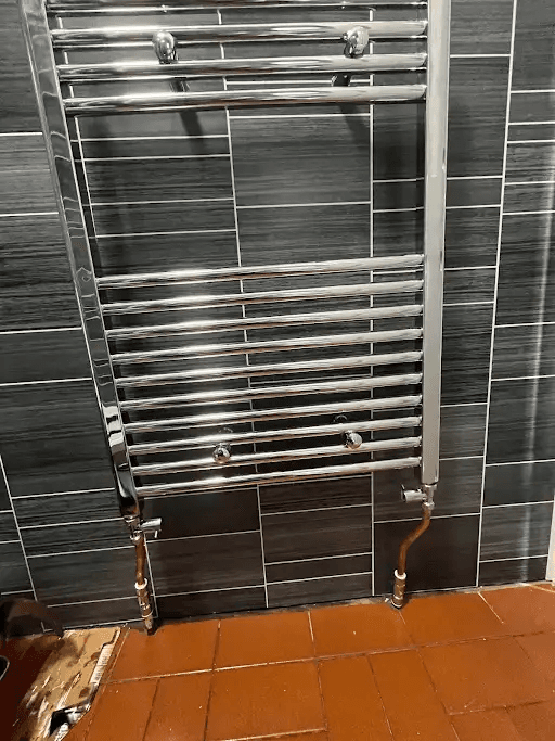 Chrome towel radiator installation in a bathroom in Paignton